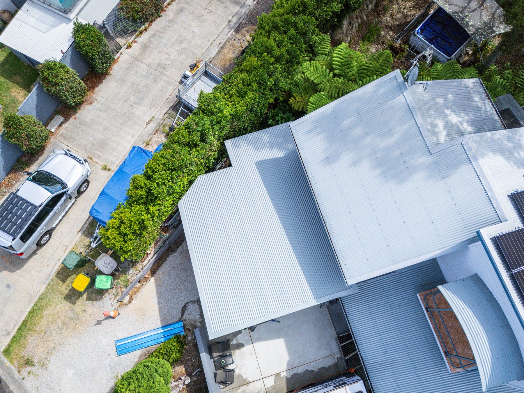 Top-down drone view of a corrugated re-roof and carport