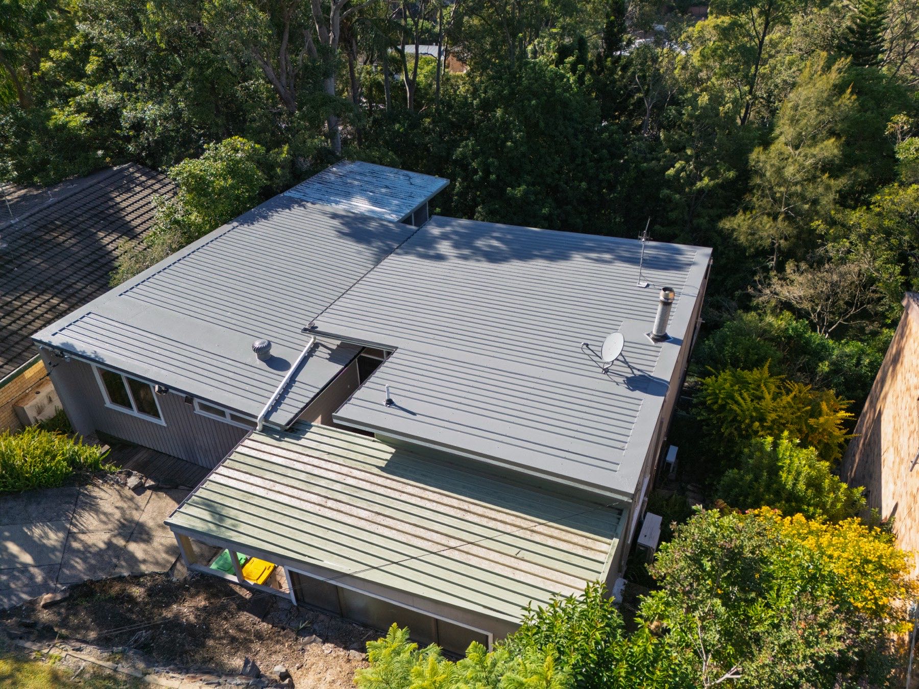 Drone view of a metal re-roof among trees, Kotara